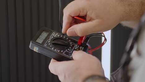 Close-up-of-the-device-of-a-working-electrician-checking-the-presence-of-voltage-in-the-network